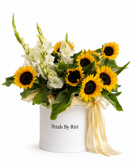 Vibrant yellow sunflowers and white gladiolus floral arrangement in a luxury white hatbox with a gold ribbon by Petals By Riri